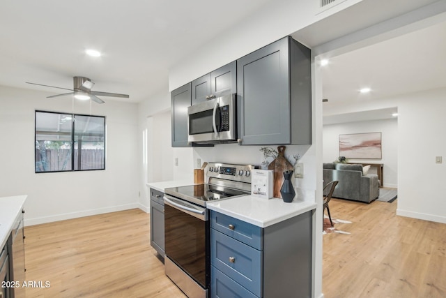 kitchen with ceiling fan, appliances with stainless steel finishes, and light hardwood / wood-style flooring