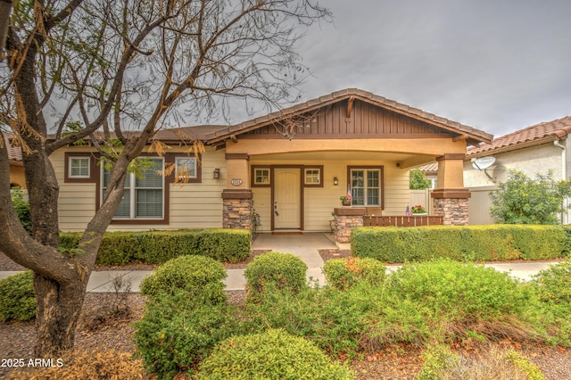 craftsman-style house featuring a porch and stone siding