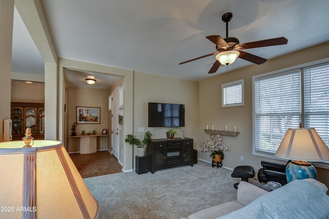 living area with carpet, baseboards, and ceiling fan