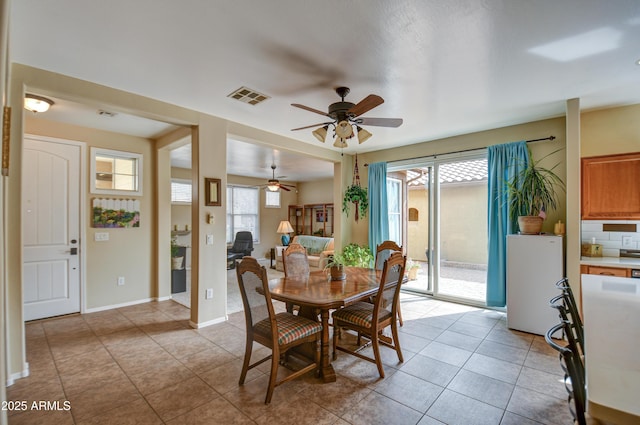 dining space with visible vents, ceiling fan, baseboards, and light tile patterned floors