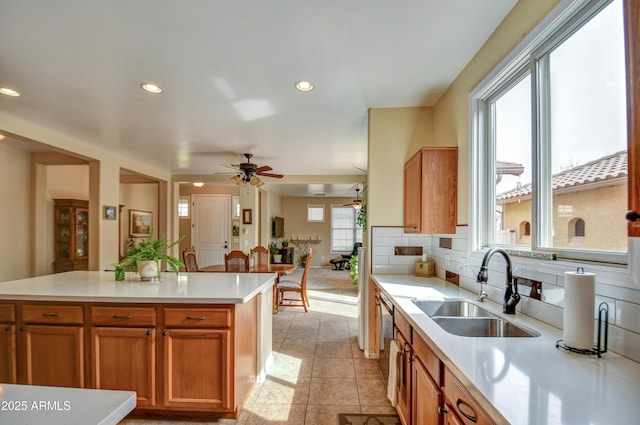 kitchen featuring light tile patterned floors, recessed lighting, light countertops, backsplash, and a sink