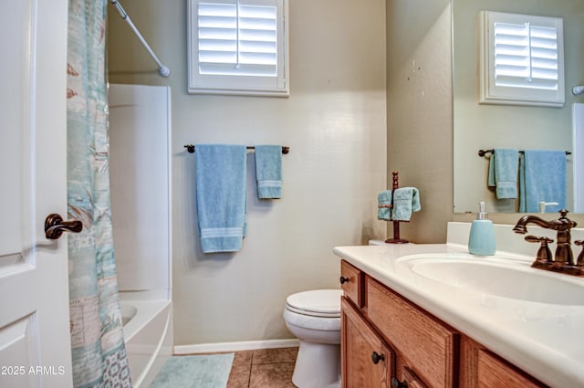 bathroom with toilet, a healthy amount of sunlight, tile patterned flooring, and vanity