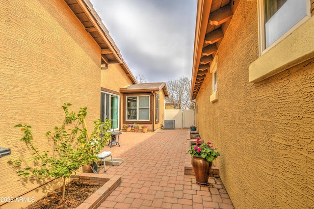 view of patio with central AC unit and fence