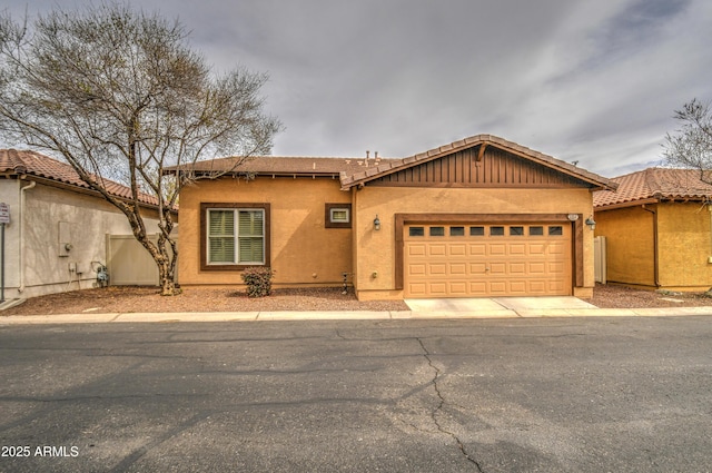 view of front of house featuring a garage, concrete driveway, and stucco siding