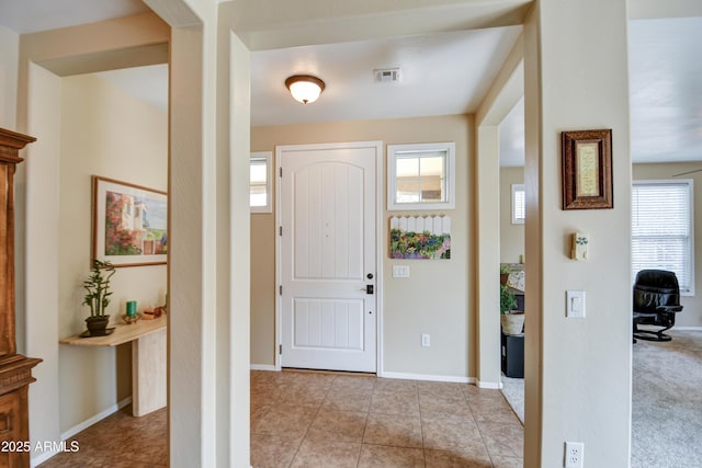 tiled entryway featuring visible vents and baseboards