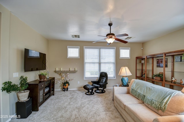 carpeted living room with a wealth of natural light, visible vents, and baseboards