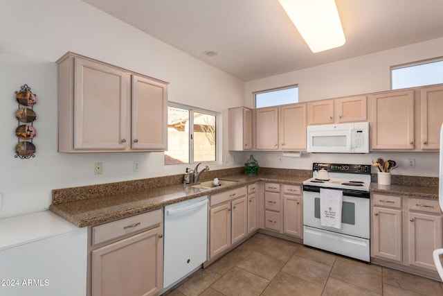 kitchen with light brown cabinets, white appliances, sink, and light tile patterned floors