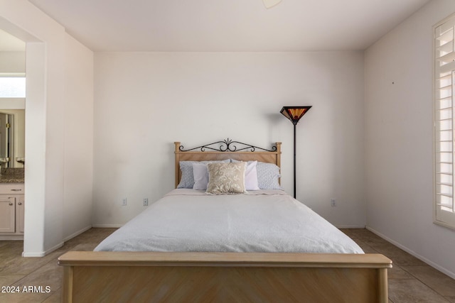 bedroom with connected bathroom and light tile patterned flooring