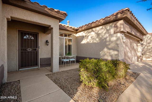 view of exterior entry with a patio