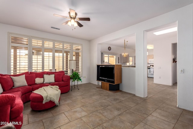 living room featuring ceiling fan with notable chandelier