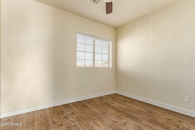 empty room with visible vents, ceiling fan, baseboards, and wood finished floors