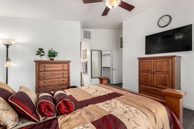 bedroom featuring a ceiling fan, visible vents, baseboards, and wood finished floors