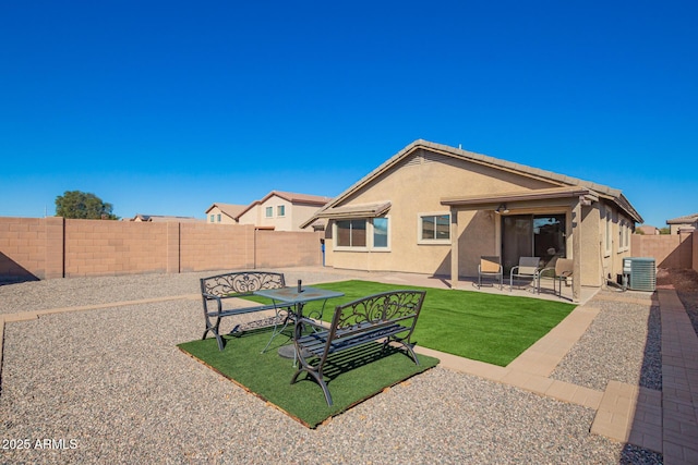 back of house with a patio, a fenced backyard, central air condition unit, a yard, and stucco siding