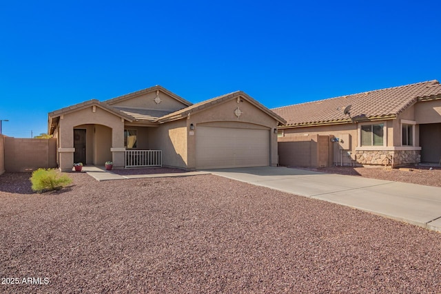 view of front of home featuring a tiled roof, an attached garage, fence, and stucco siding