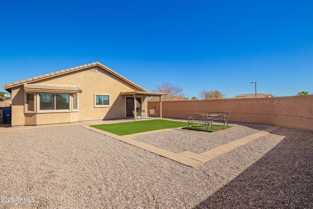 back of house with a patio area, a fenced backyard, and stucco siding