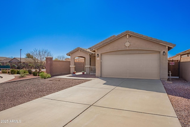 view of front of home with a garage, driveway, fence, and stucco siding