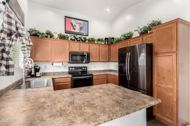 kitchen featuring electric range, a sink, light countertops, freestanding refrigerator, and stainless steel microwave