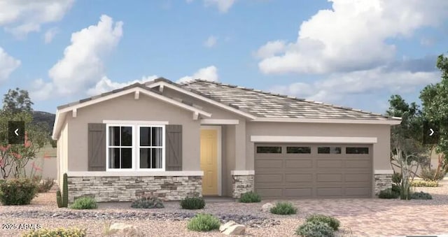 11412 S 50th Ln, Laveen, AZ 85339 - view of front facade featuring stone siding, a garage, decorative driveway, and stucco siding