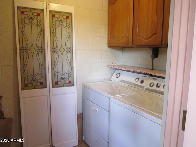 washroom featuring cabinets and washer and clothes dryer