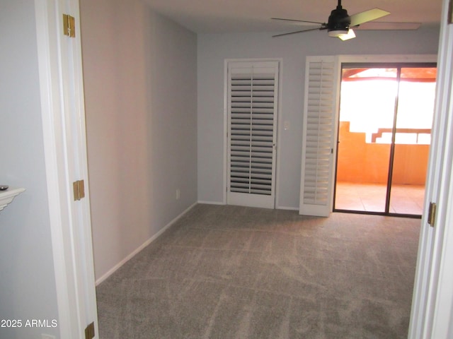 carpeted spare room featuring ceiling fan