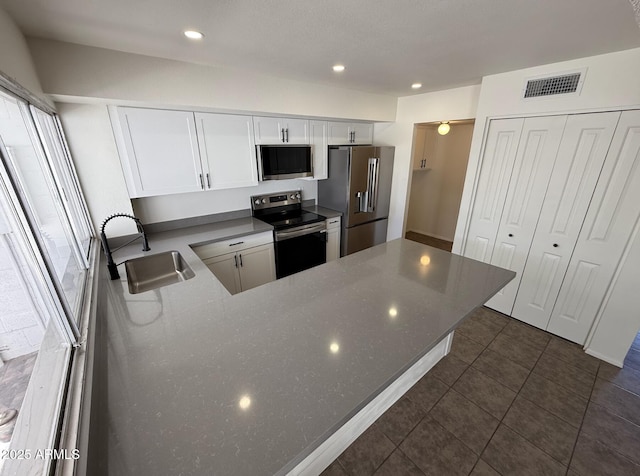 4849 W Northern Ave, Glendale, AZ 85301 - kitchen featuring appliances with stainless steel finishes, white cabinets, a peninsula, dark tile patterned flooring, and recessed lighting