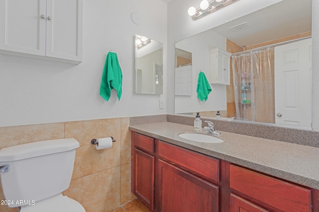 bathroom featuring tile walls, vanity, and toilet