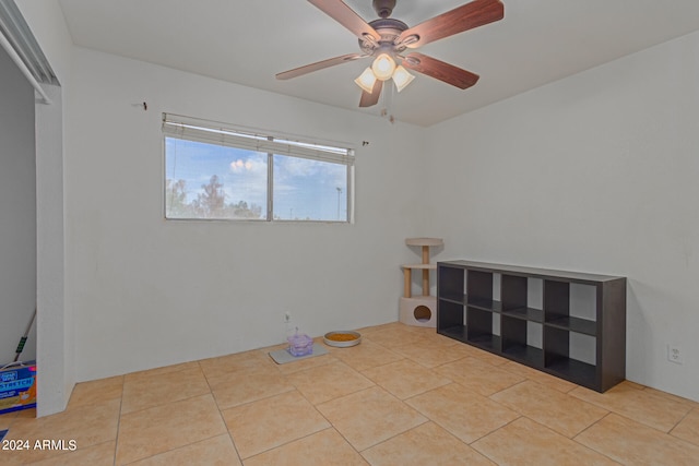 tiled spare room with ceiling fan