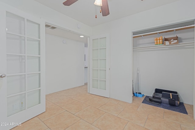 interior space with light tile patterned floors and ceiling fan