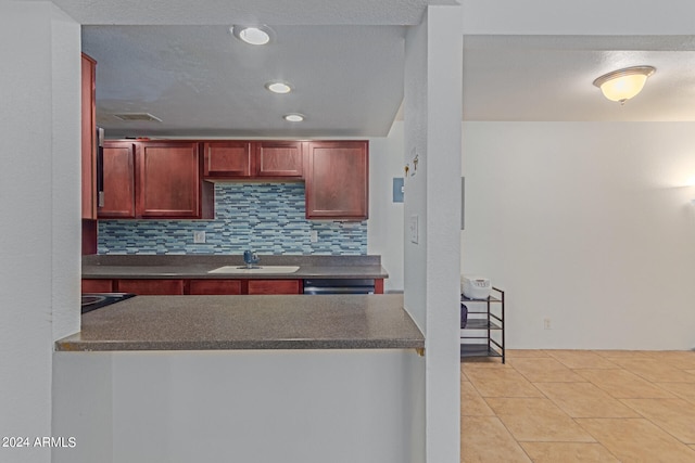 kitchen with sink, backsplash, light tile patterned floors, and dishwasher