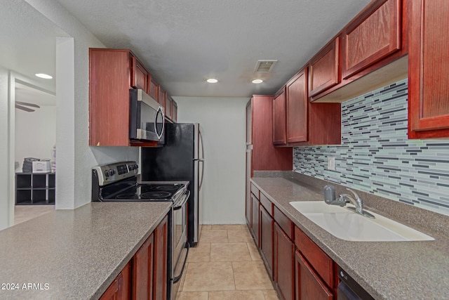 kitchen featuring light tile patterned floors, appliances with stainless steel finishes, sink, and tasteful backsplash