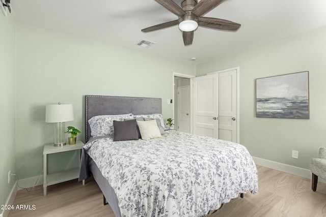 bedroom featuring light wood-type flooring, a closet, and ceiling fan