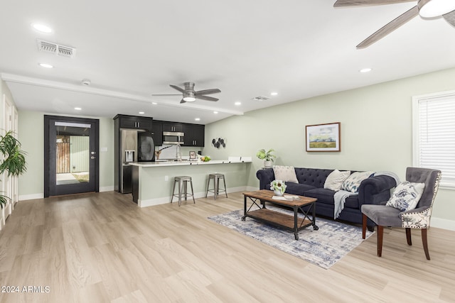 living room featuring light hardwood / wood-style flooring and ceiling fan