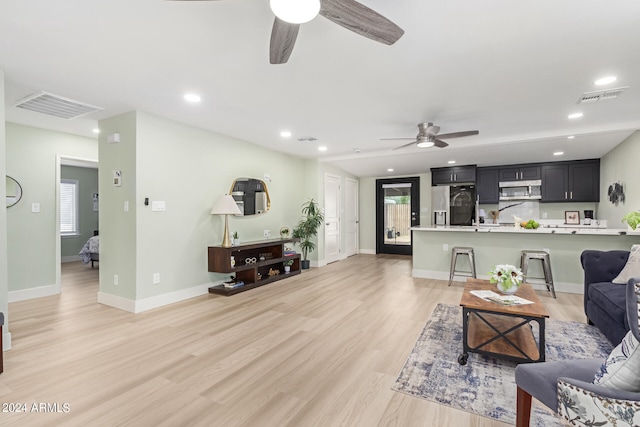 living room with light wood-type flooring and ceiling fan