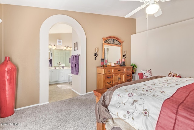 bedroom with light carpet, ceiling fan, and ensuite bathroom