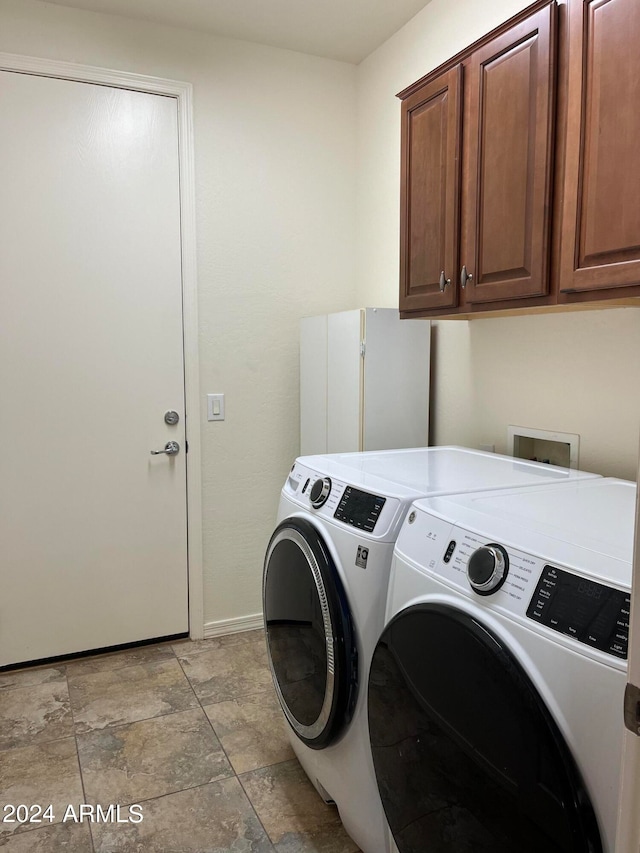 laundry area with washer and dryer and cabinets