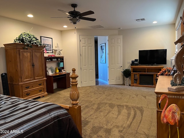 carpeted bedroom featuring ceiling fan and a fireplace