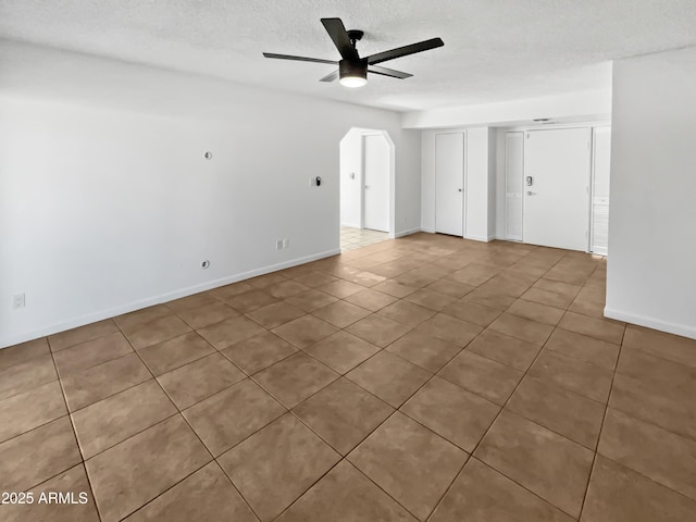 tiled empty room featuring a textured ceiling and ceiling fan