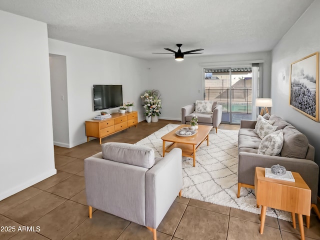 tiled living room featuring ceiling fan and a textured ceiling