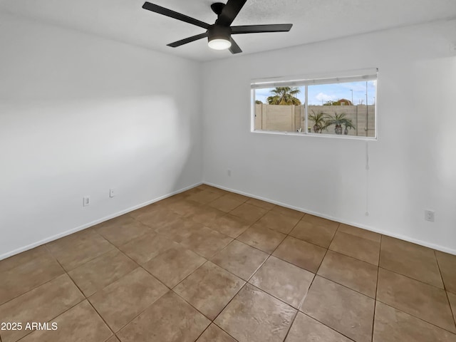 tiled empty room featuring ceiling fan