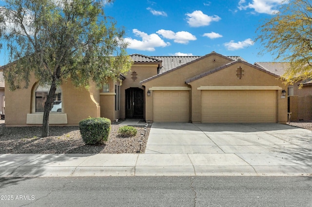 mediterranean / spanish home featuring a garage, a tile roof, driveway, and stucco siding