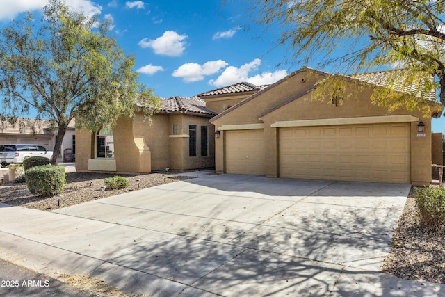 mediterranean / spanish house featuring a garage, driveway, a tile roof, and stucco siding