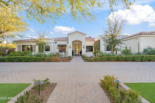 mediterranean / spanish-style home with a tiled roof and stucco siding