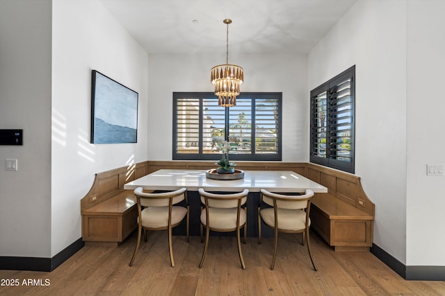 dining room with a chandelier, breakfast area, light wood-type flooring, and baseboards