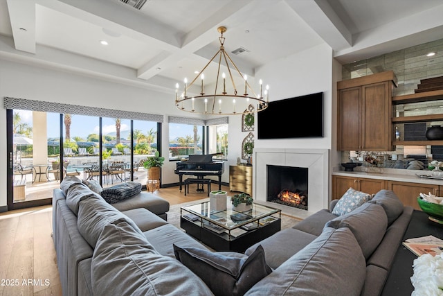 living room featuring light wood finished floors, visible vents, coffered ceiling, and a tiled fireplace