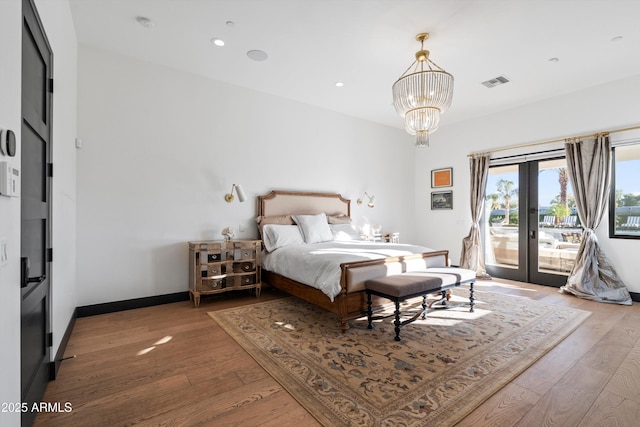 bedroom featuring access to exterior, french doors, visible vents, and wood finished floors