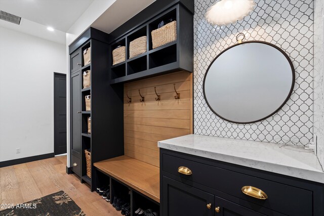 mudroom featuring light wood-style floors, baseboards, and visible vents