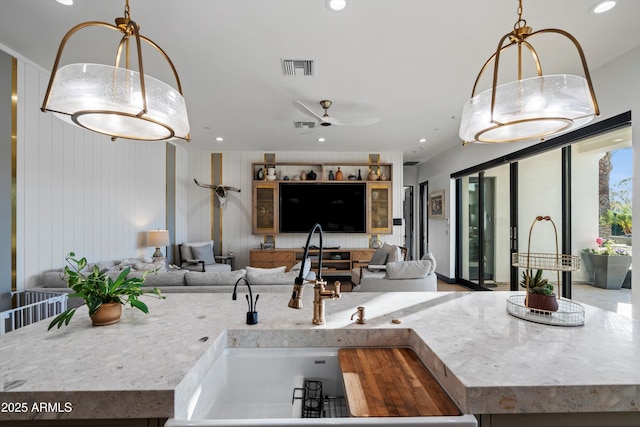 kitchen with recessed lighting, light countertops, visible vents, open floor plan, and a sink