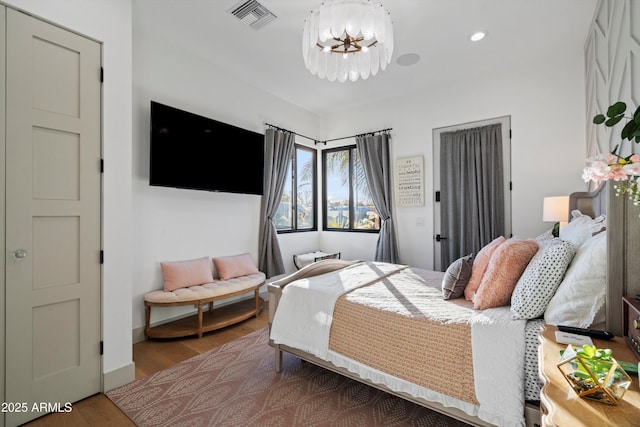 bedroom featuring a notable chandelier, recessed lighting, wood finished floors, visible vents, and baseboards