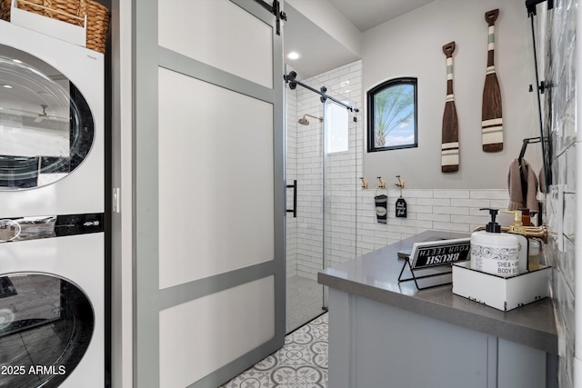 bathroom featuring a shower stall and stacked washer / drying machine