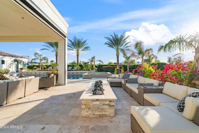 view of patio with an outdoor living space with a fire pit and an outdoor pool